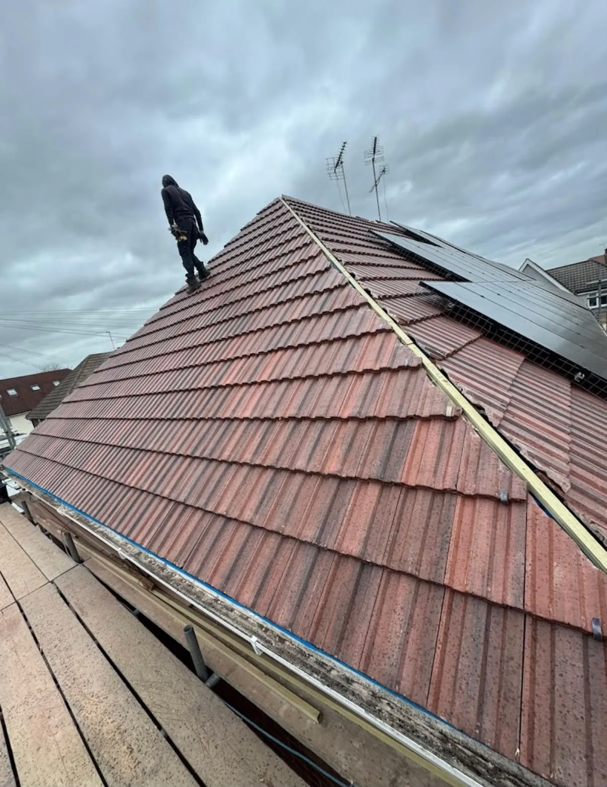 Roof repair re-tiling a hip section on a red tile roof in Leicester
