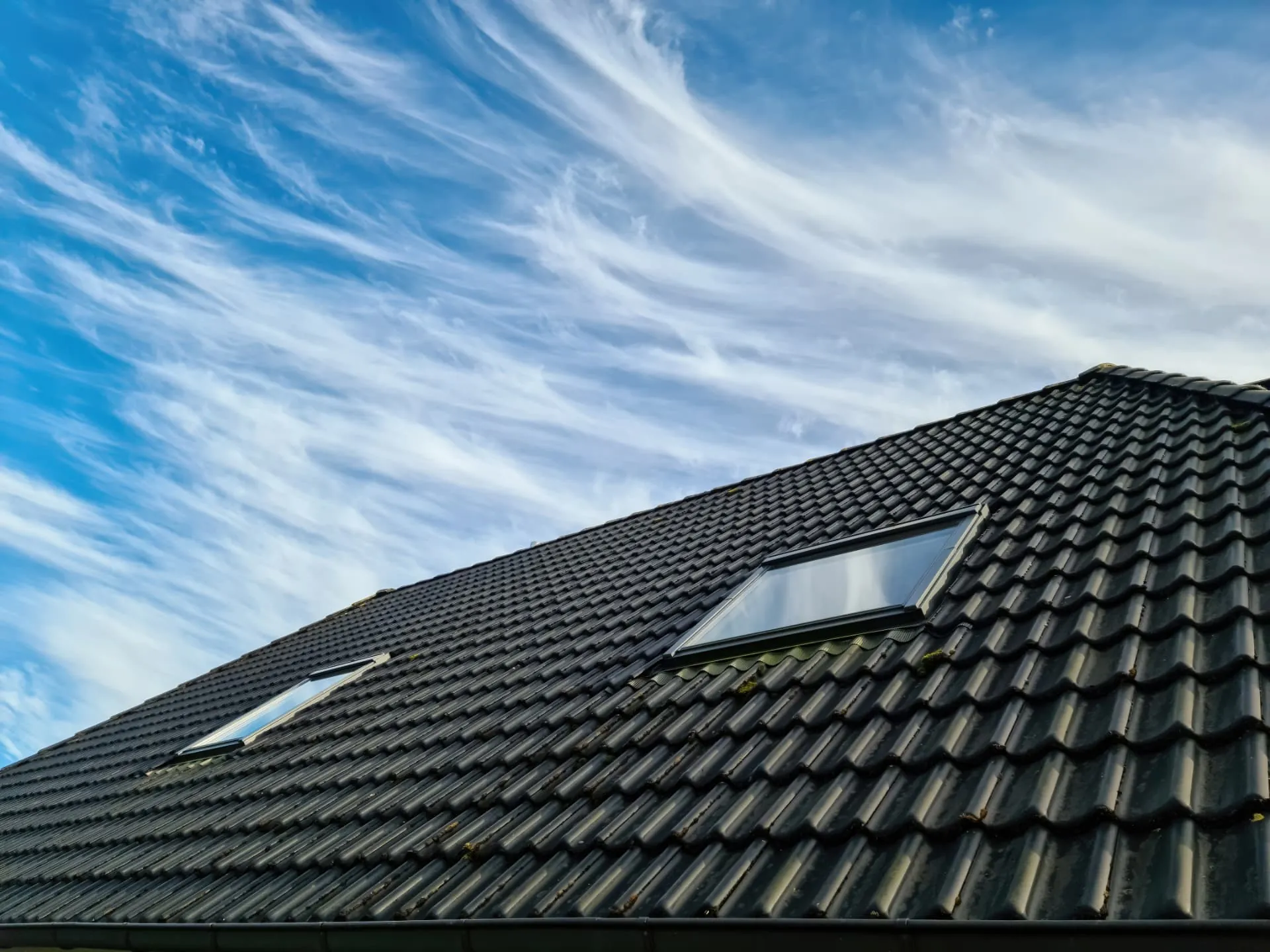 Velux roof windows in a dark tiled roof