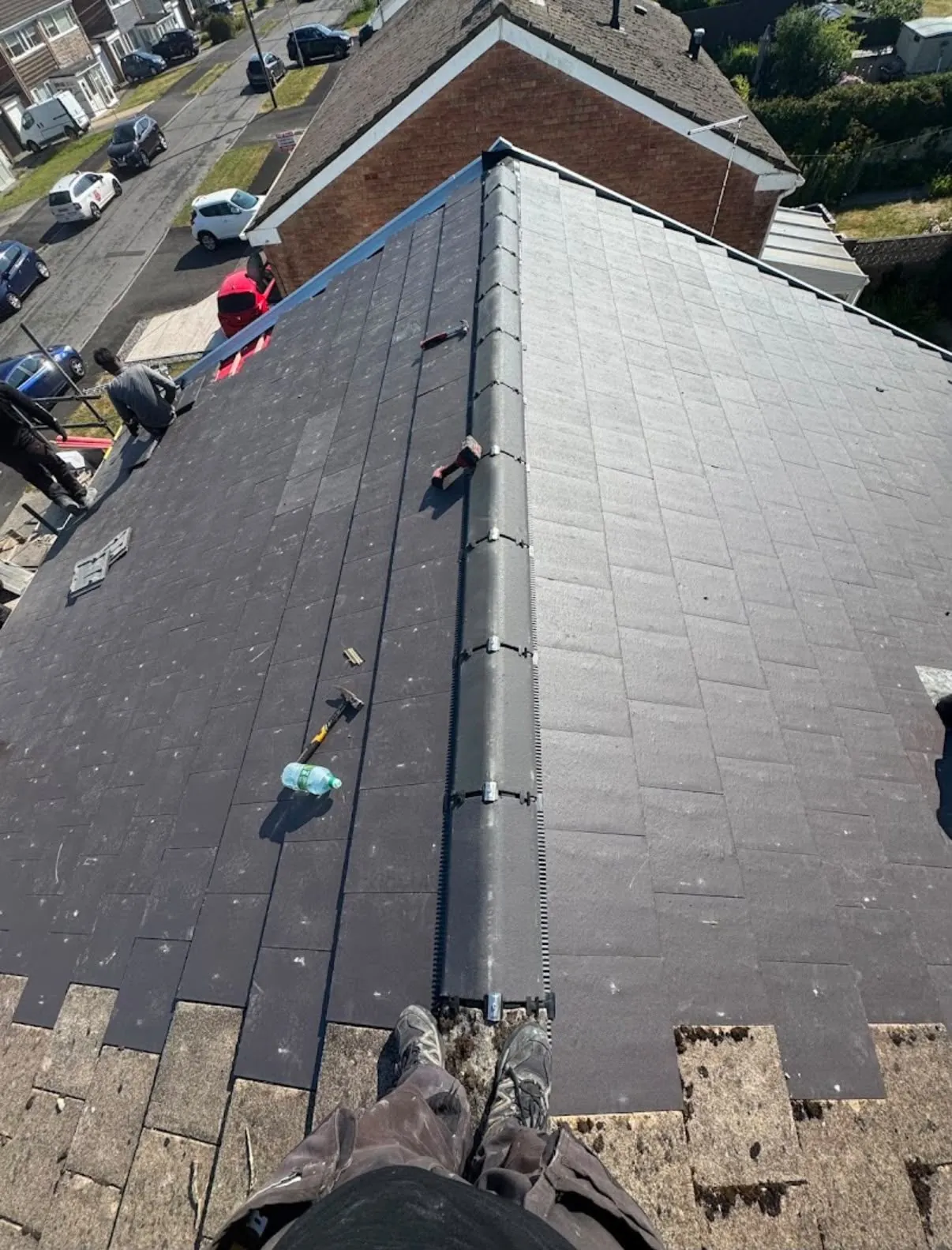 Roof replacement in progress with new dark tiles and dry ridge in Leicester