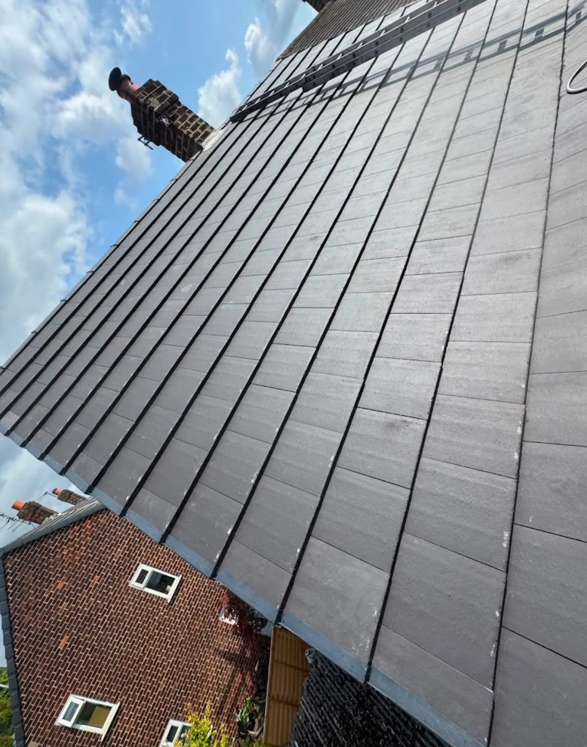 Newly laid grey slate-effect roof tiles on a Leicester house